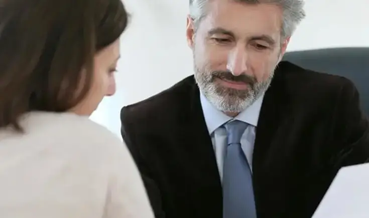 Closeup of two people looking over a document