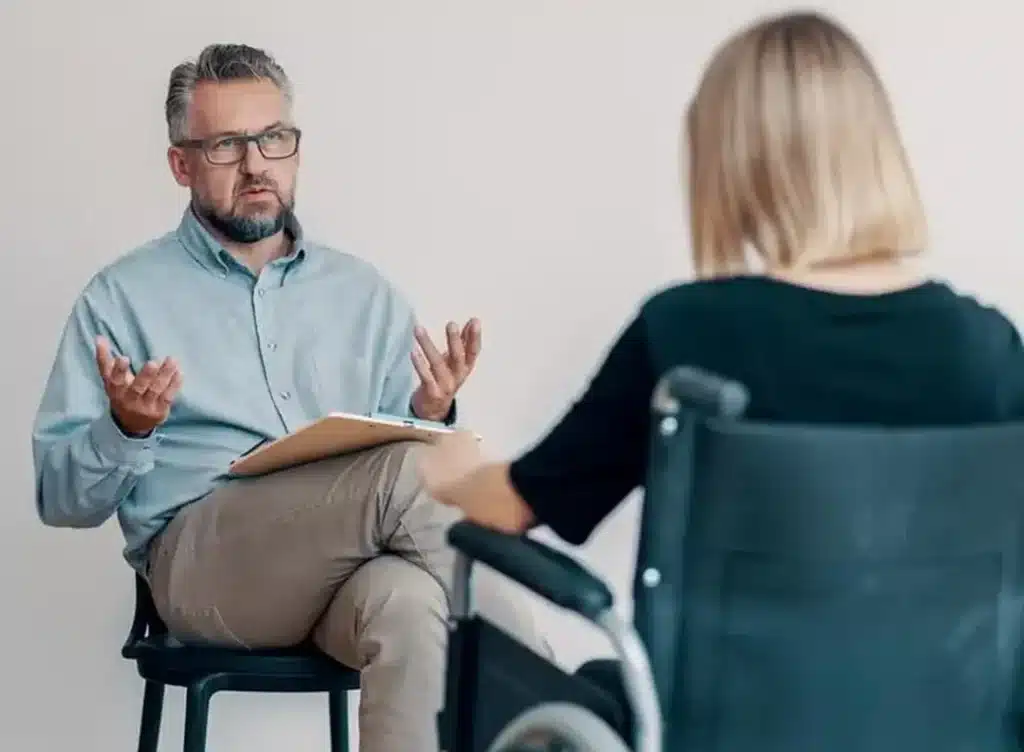 Therapist talking to patient in wheelchair