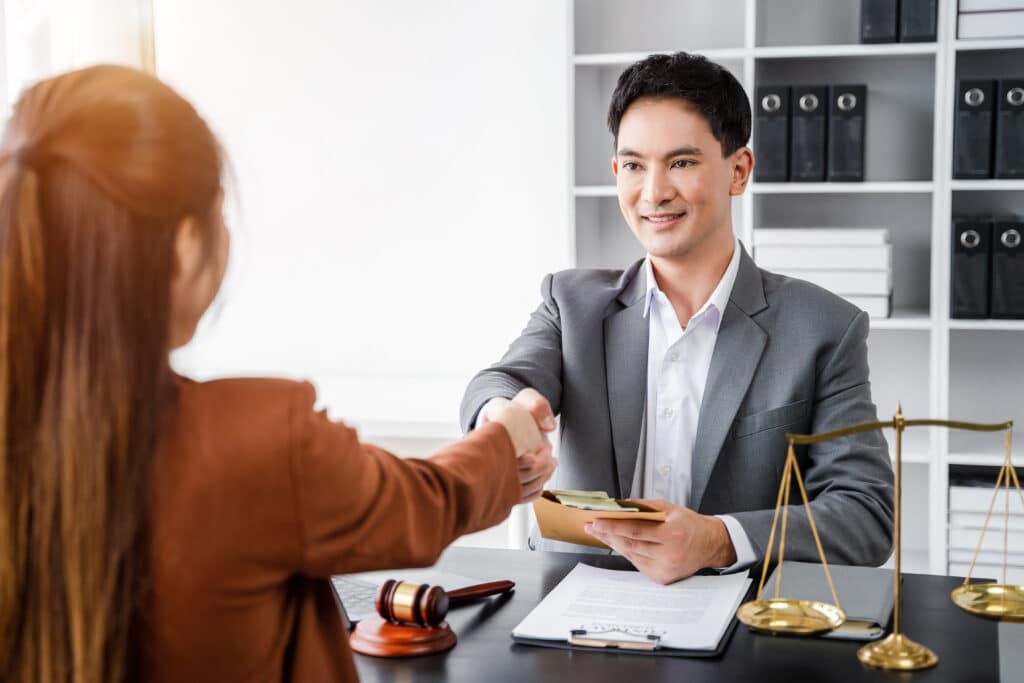 Lawyer shaking hands with client in office
